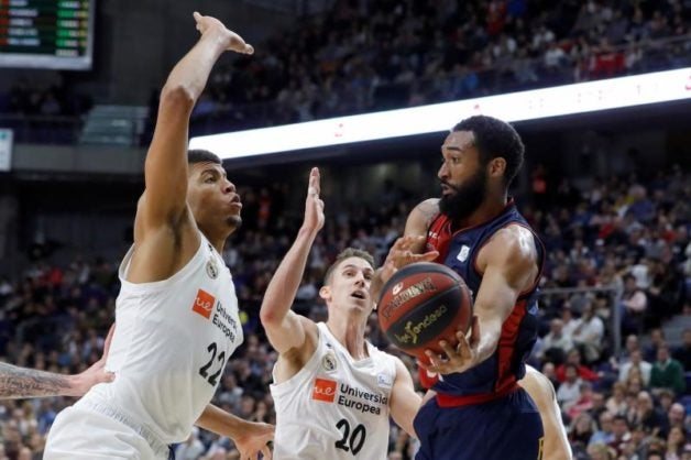 El estadounidense Darrun Hilliard (d), del Baskonia, entra a canasta ante Edy Tavares (i) y Jaycee Carroll (c), ambos del Real Madrid, durante el partido de la jornada 20ª de Liga ACB. EFE/Juanjo Martin